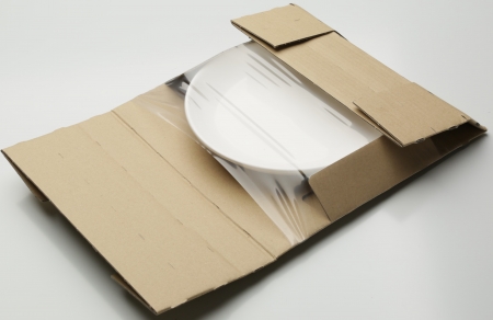 白い平皿をフィルム梱包材で梱包した画像